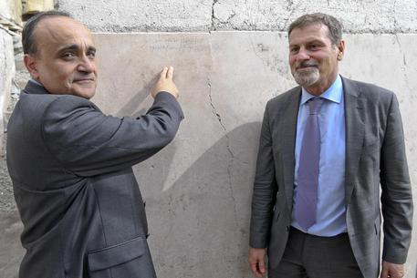 Il ministro Alberto Bonisoli con il sovrintendente Massimo Osanna mostrano la scritta su un muro  degli scavi di Pompei /FOTO CIRO FUSCO © ANSA