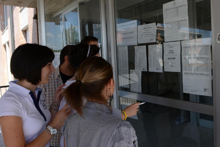 Ragazzi di un liceo di Pontedera controllano i voti della prova di maturita ' - RIPRODUZIONE RISERVATA