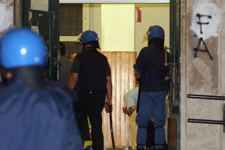 Poliziotti all 'ingresso della scuola Diaz di Genova in una foto d 'archivio - RIPRODUZIONE RISERVATA