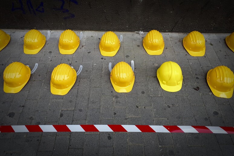 Caschi gialli per terra ad una manifestazione sulla sicurezza sul lavoro - RIPRODUZIONE RISERVATA