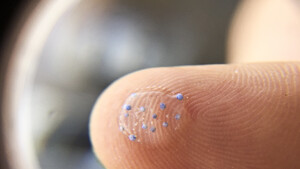 Microplastiche su un polpastrello viste attraverso una lente d'ingrandimento (fonte: MPCA Photos da Flickr) (ANSA)