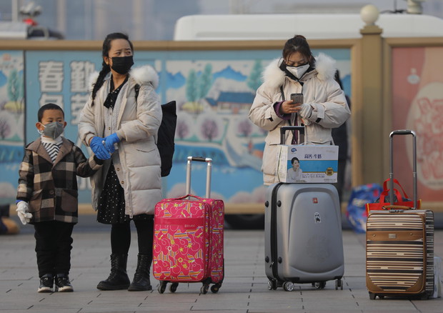 Viaggiatori indossano le mascherine di protezione © EPA