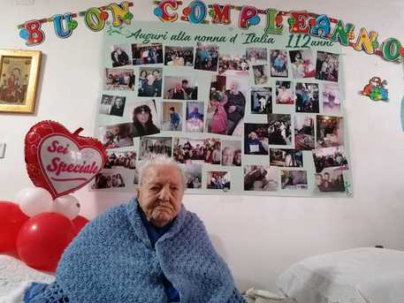 Una foto fornita dalla famiglia di Maria Oliva, che tutti chiamano Marietta, mostra la 'nonna  d'Italia' che festeggia in una stanza addobbata di fiori e palloncini, i suoi 112 anni di vita a Piazza Armerina © ANSA