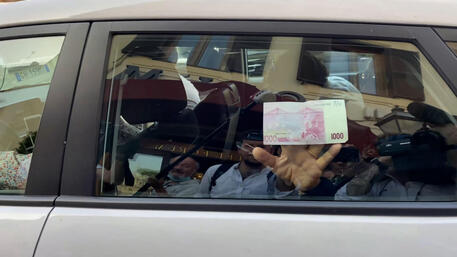 Siparietto di Beppe Grillo, che ha mostrato una banconota da mille euro, taglio inesistente, salendo sul taxi che lo ha portato alla Camera © ANSA