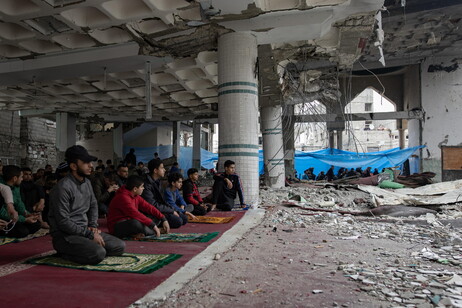 Palestinians perform Friday prayers in the ruins of Al-Huda Mosque