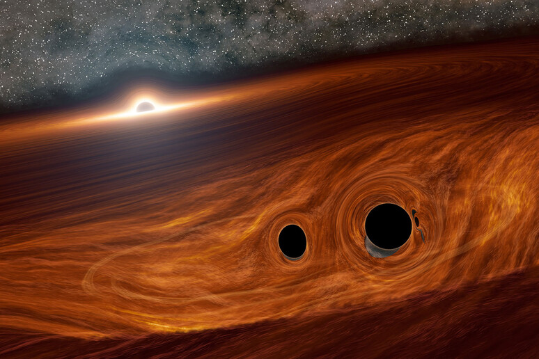 Rappresentazione artistica di un buco nero massiccio circondato da un disco di gas, all 'interno del quale collidono due piccoli buchi neri (fonte: Caltech/R. Hurt, IPAC) - RIPRODUZIONE RISERVATA