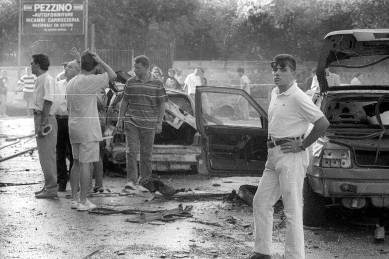 Inquirenti, pompieri e gente comune in via D 'Amelio a Palermo subito dopo l 'attentato del 19 luglio  1992 in cui persero la vita il giudice Paolo Borsellino e la sua scorta. ANSA - RIPRODUZIONE RISERVATA