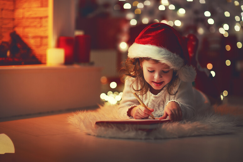 Una bambina scrive la letterina a Babbo Natale foto iStock. - RIPRODUZIONE RISERVATA