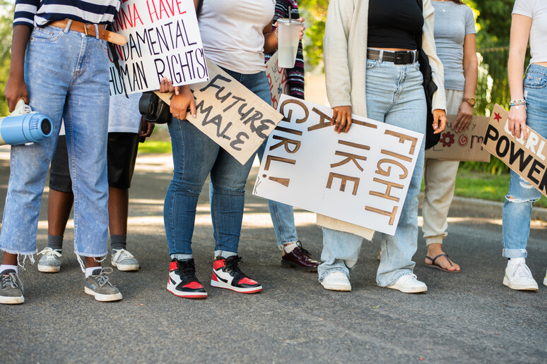 Group of young women standing with signs during a women 's day march - RIPRODUZIONE RISERVATA