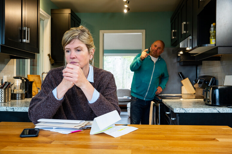 A man shouting at his female partner over home finances and debt. foto iStock. - RIPRODUZIONE RISERVATA